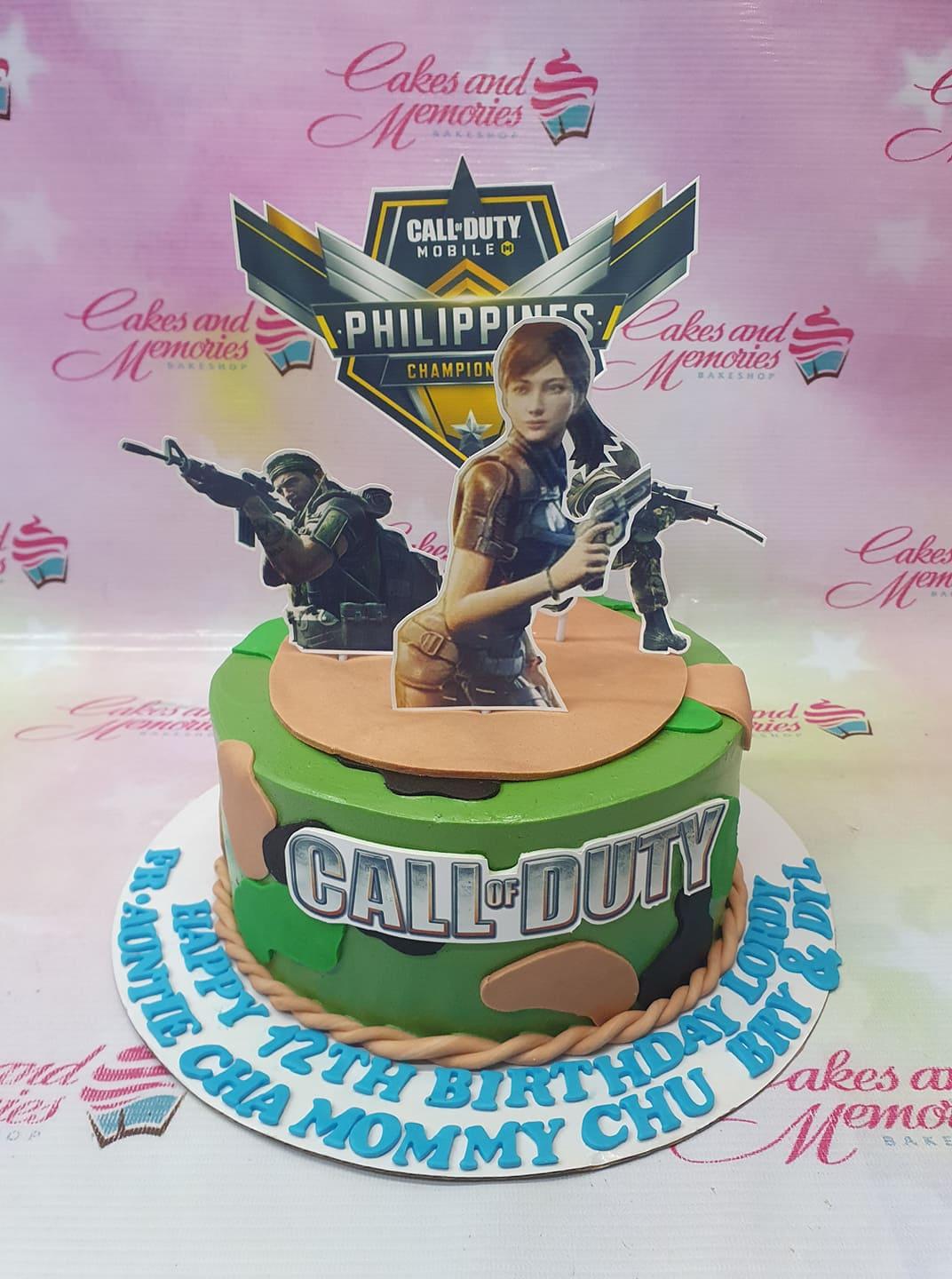 Call of Duty Mobile themed cake with camouflage icing, character printouts, and a large game logo topper.