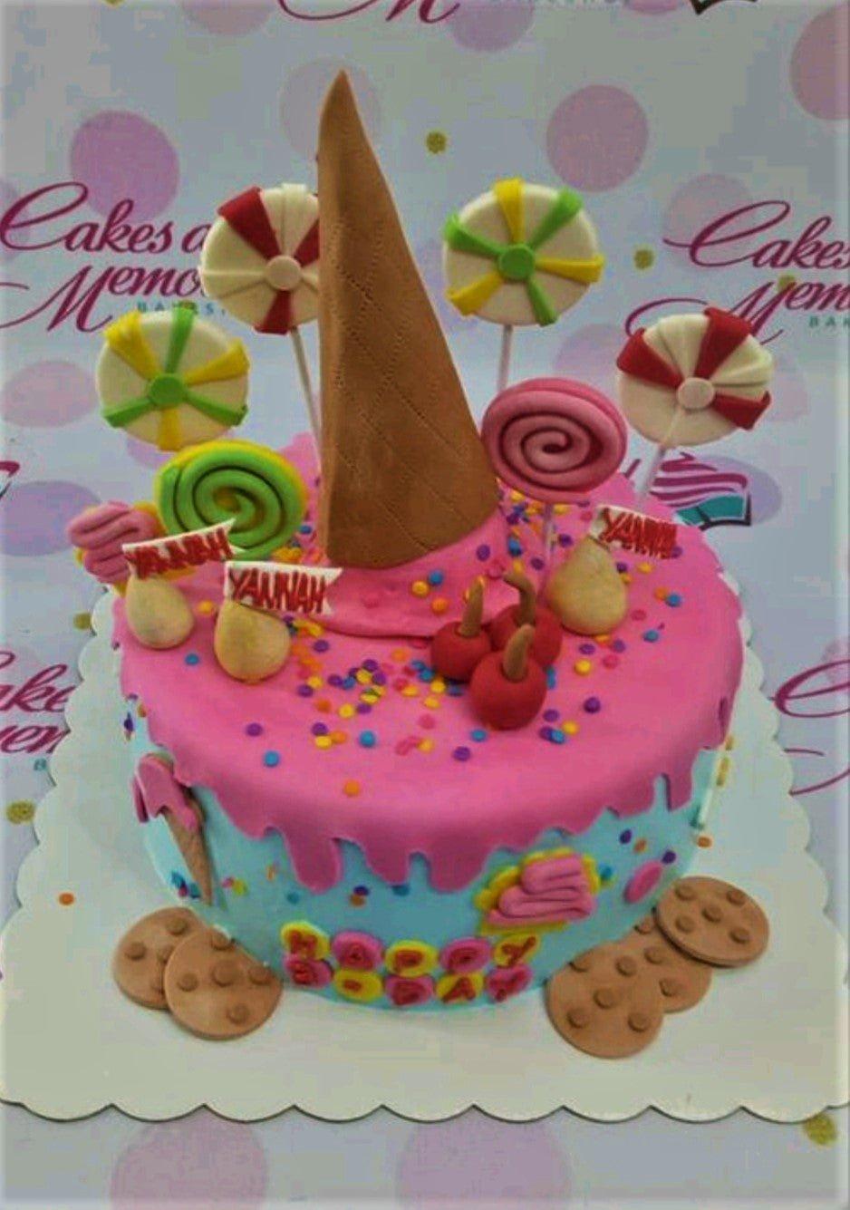 Vibrant candy-themed birthday cake with pink drip icing, ice cream cone topper, and colorful fondant lollipops and cookies.