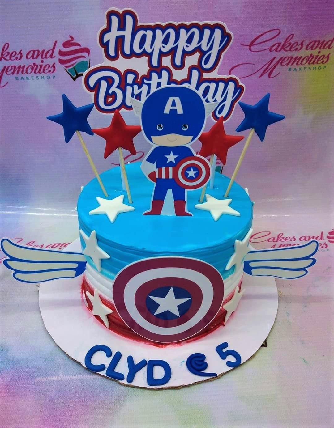 Captain America themed blue and white cake with shield and star decorations and a character topper.