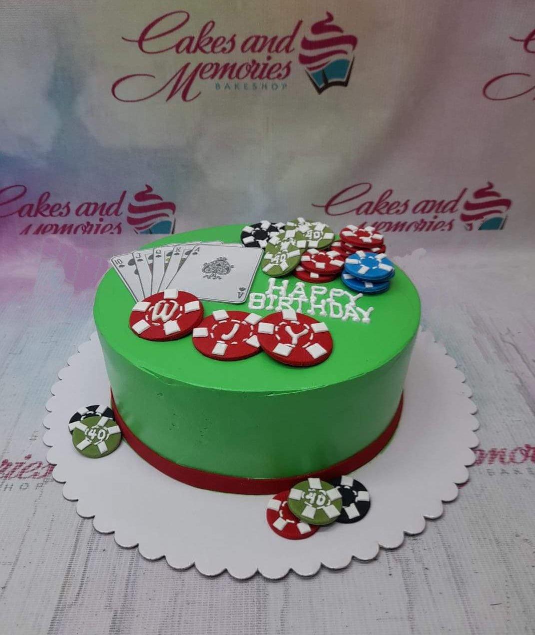 Green casino themed birthday cake with playing cards and poker chip toppers