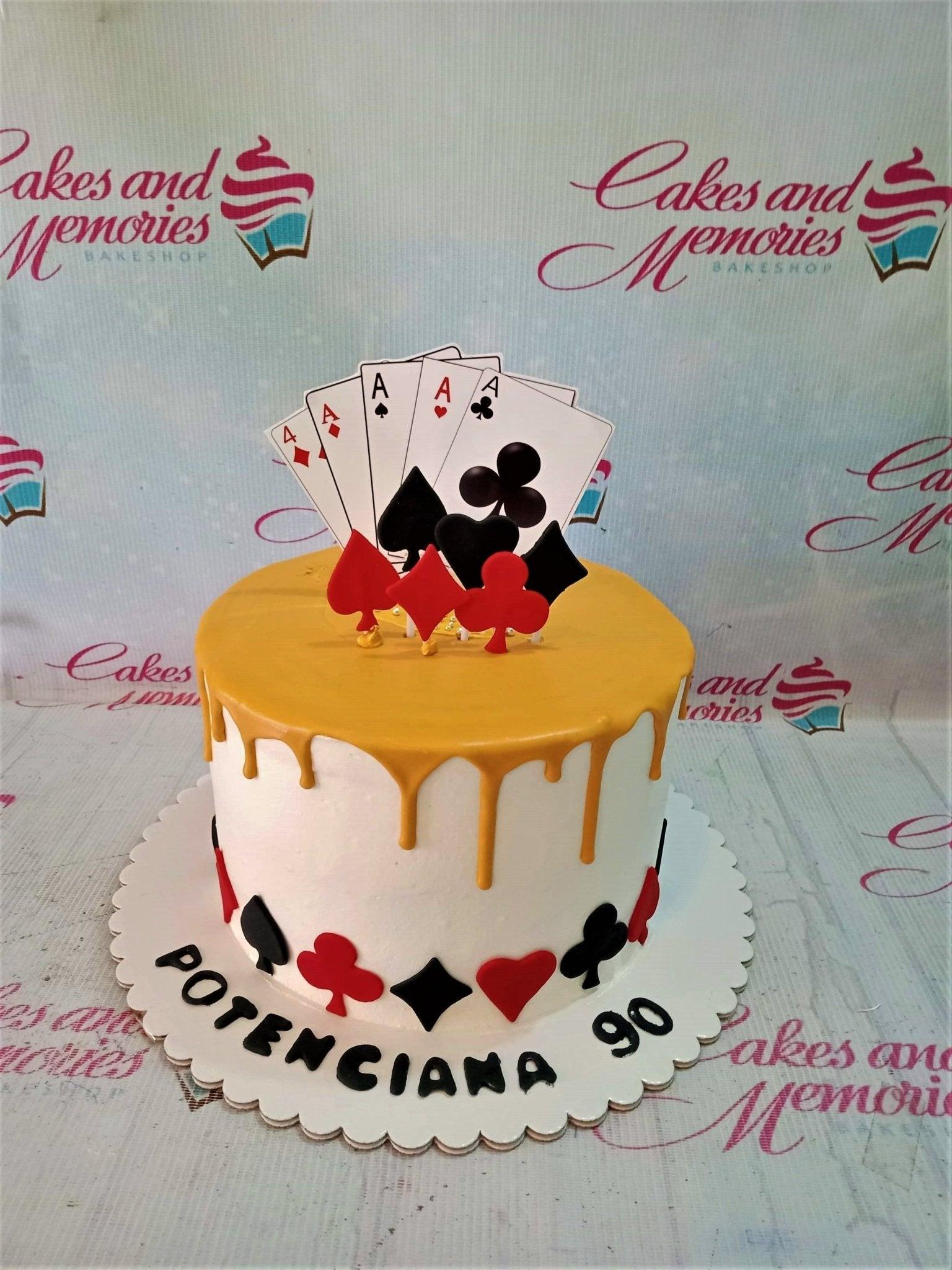 White 1-tier casino themed cake with yellow drip and playing card toppers