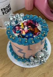 Pink 1-tier cake with blue icing borders, silver disco balls, and a printed character topper featuring three girls.