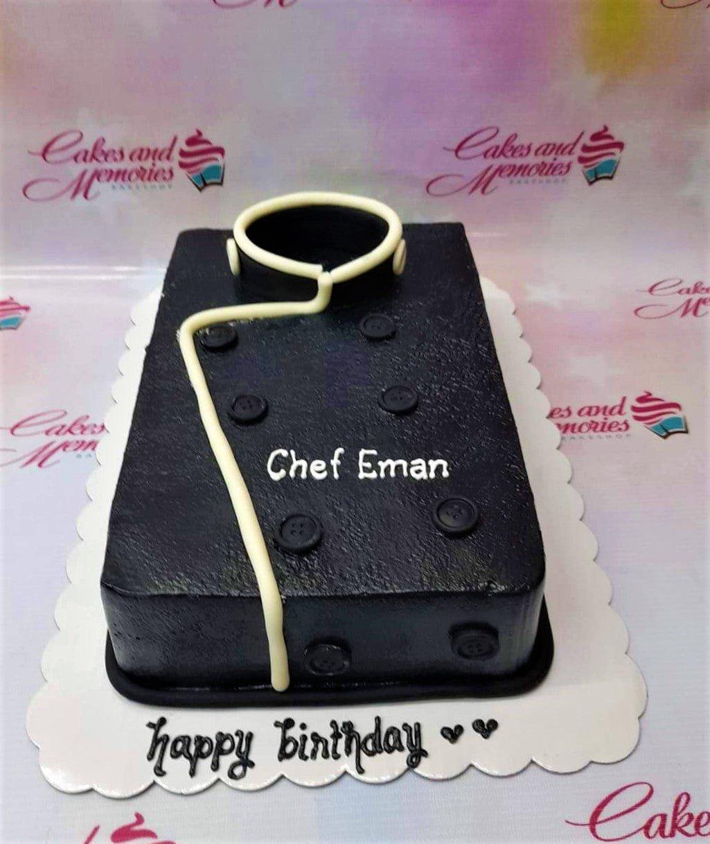 Black chef uniform rectangle cake with white collar and buttons for Chef Eman's birthday.