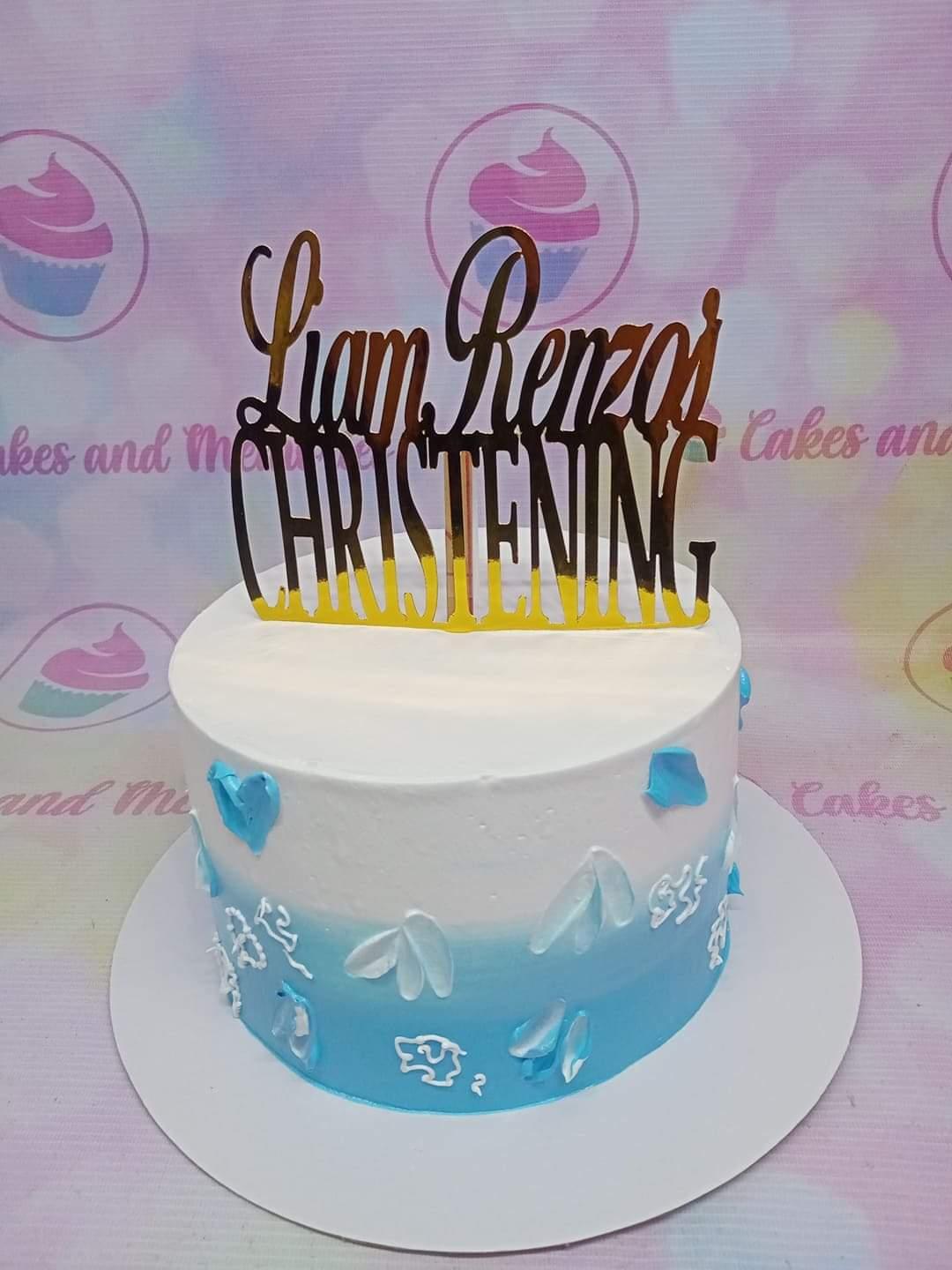 Blue and white gradient christening cake with a gold Liam Renzo's Christening topper and white palette knife icing details.