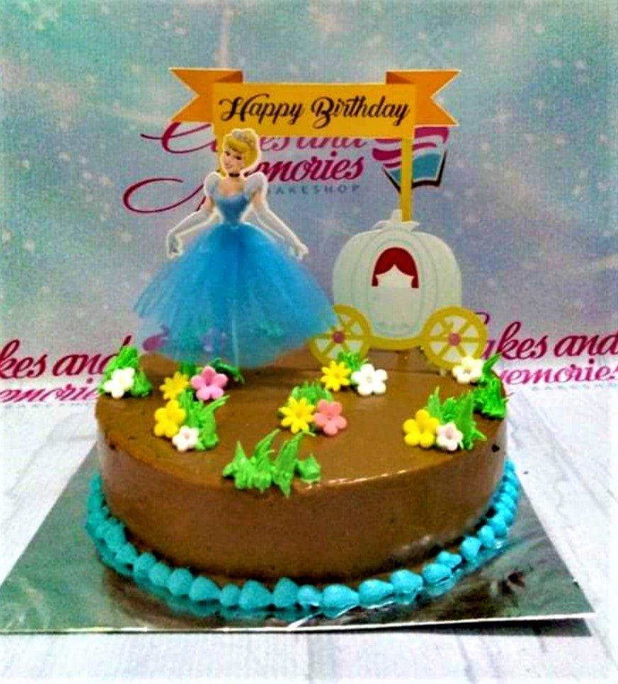 Cinderella themed chocolate cake with a blue tulle dress topper, carriage, and colorful icing flowers.