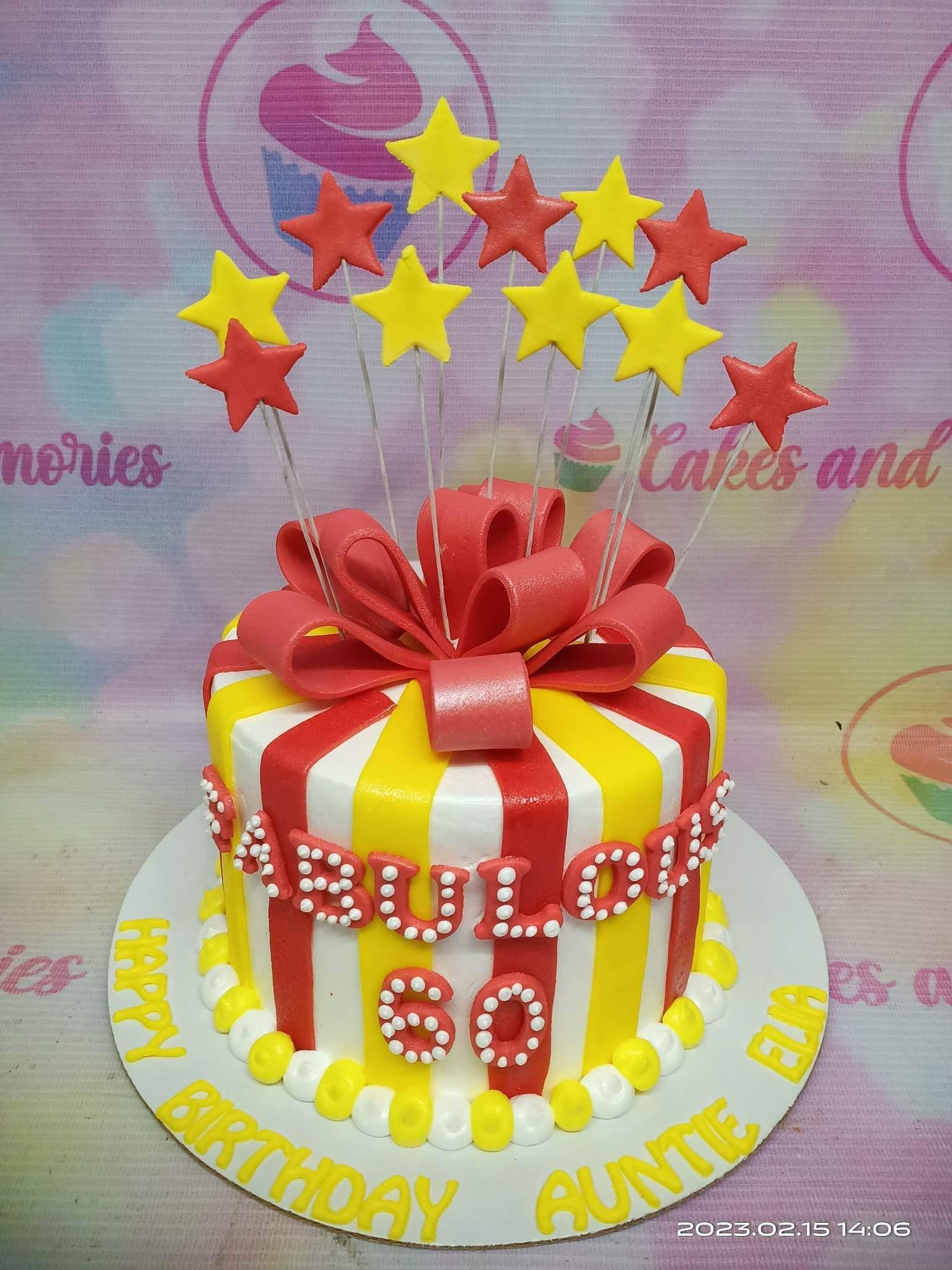 Red and yellow striped circus-themed birthday cake with a large red fondant bow and star toppers for a 60th birthday.