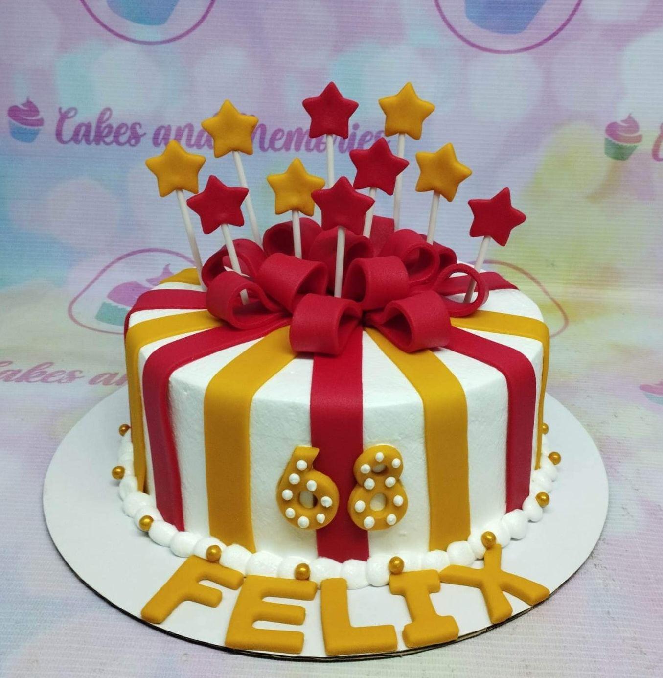 Circus themed birthday cake for Felix with red and yellow stripes, a large red fondant bow, and star toppers.