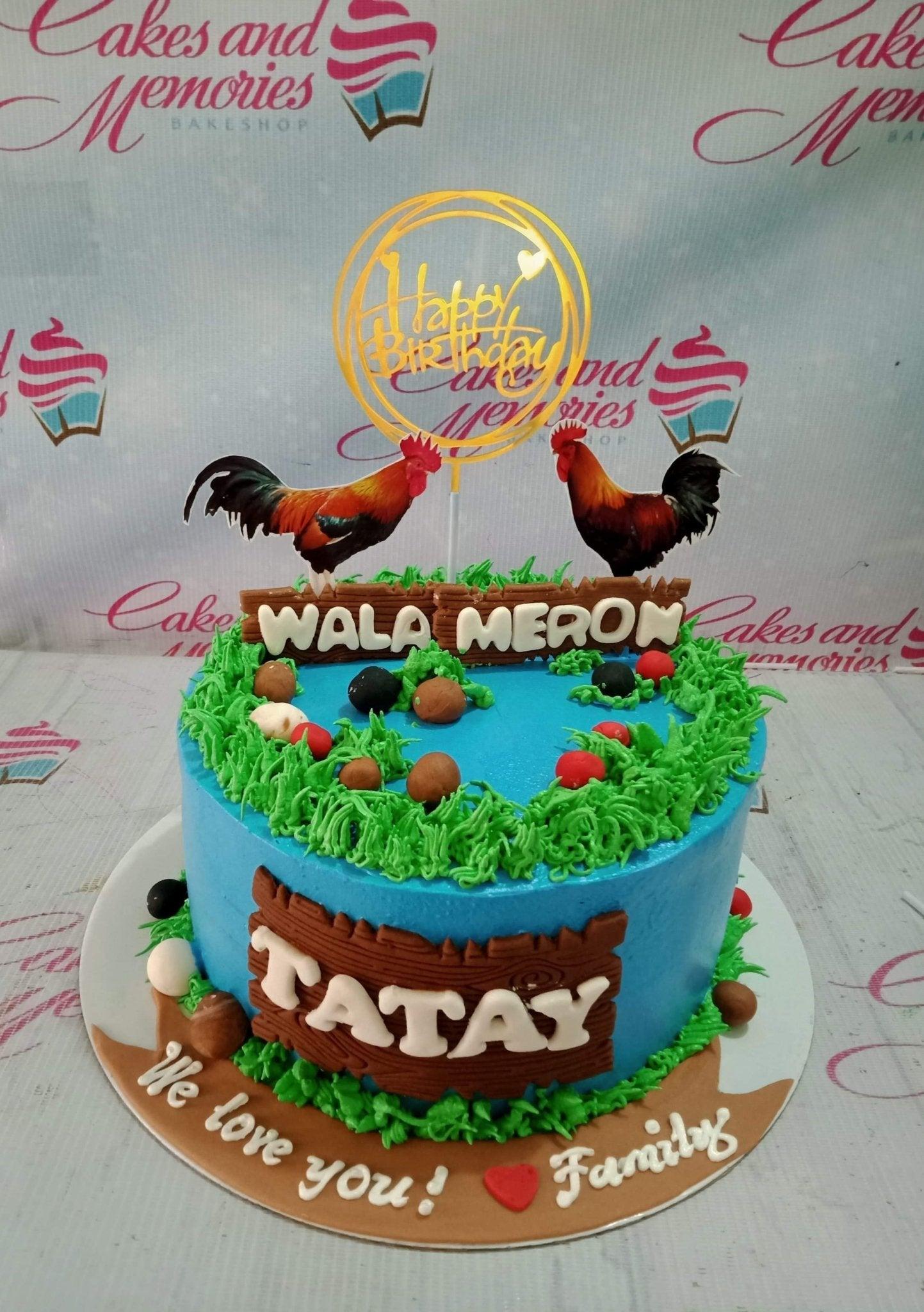 Blue cockfighting themed birthday cake with rooster printouts, green icing grass, and fondant wood panels for Tatay.