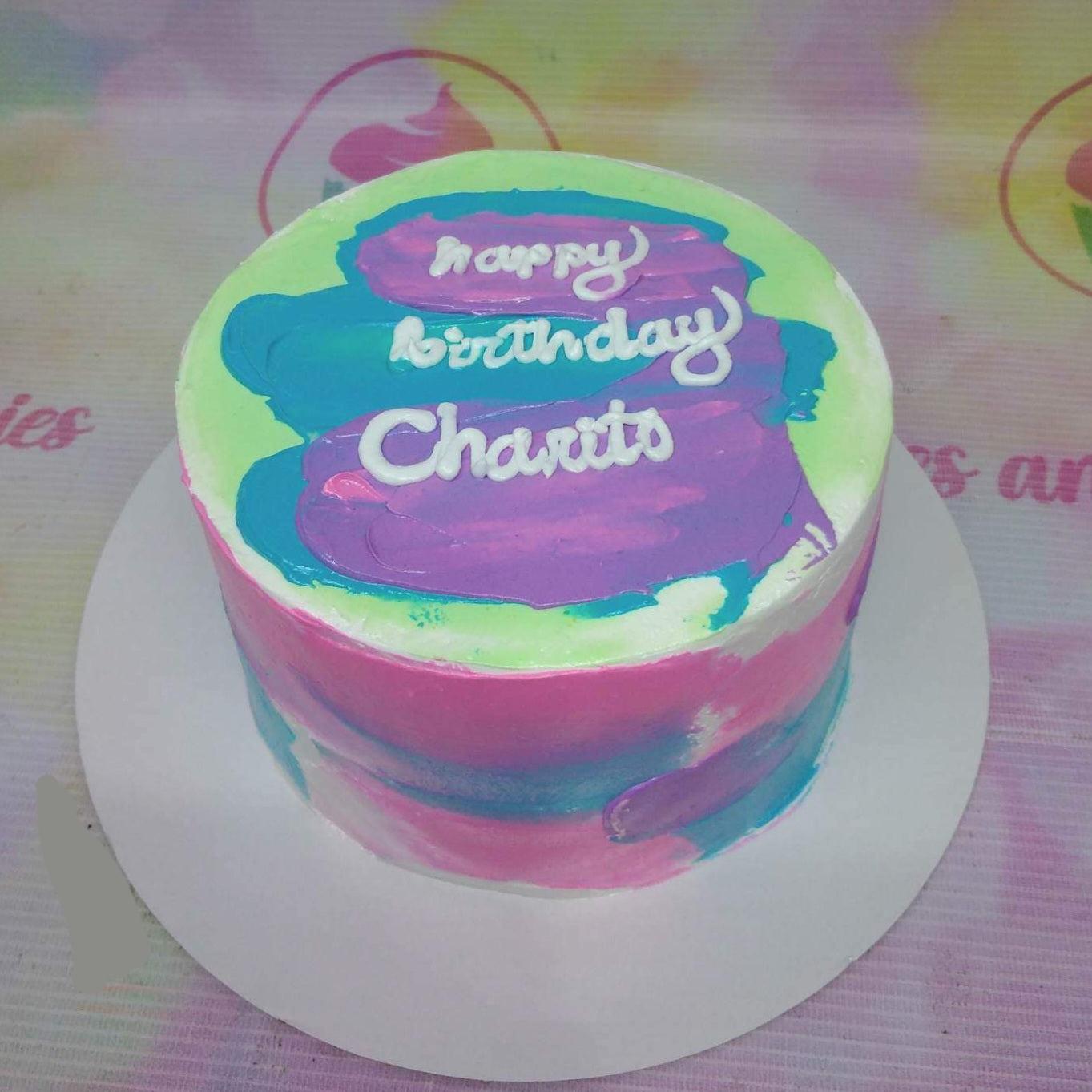 Bento cake with colorful palette knife icing in pink, blue, and purple with a white birthday message.