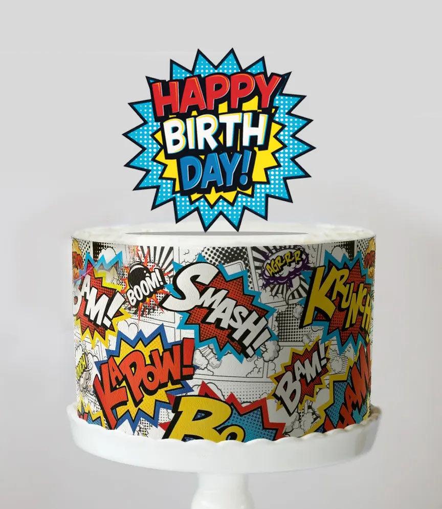 Comic book themed birthday cake with colorful pop art graphics and a large Happy Birthday speech bubble topper.