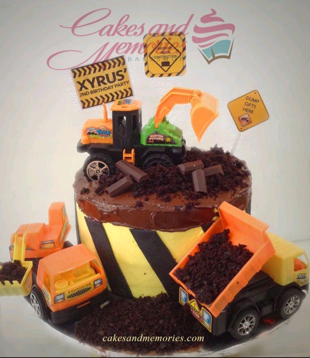 Construction themed birthday cake with yellow and black hazard stripes, chocolate icing, and toy construction vehicles.