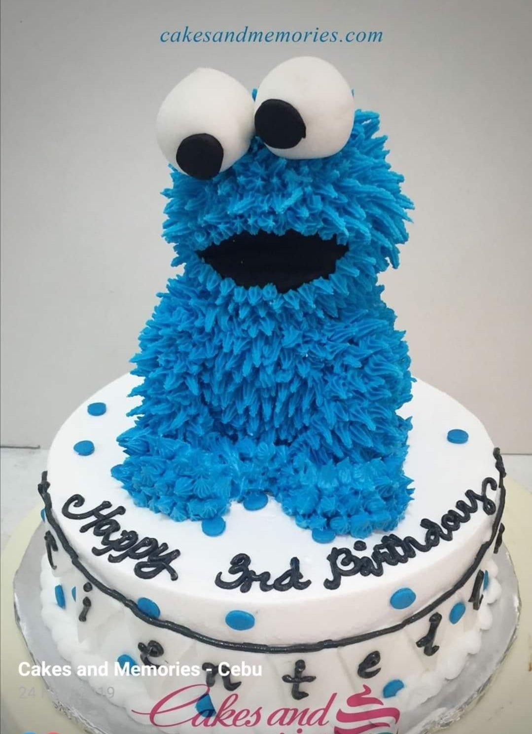 Cookie Monster themed birthday cake with blue textured icing and a large 3D Cookie Monster figure on top.