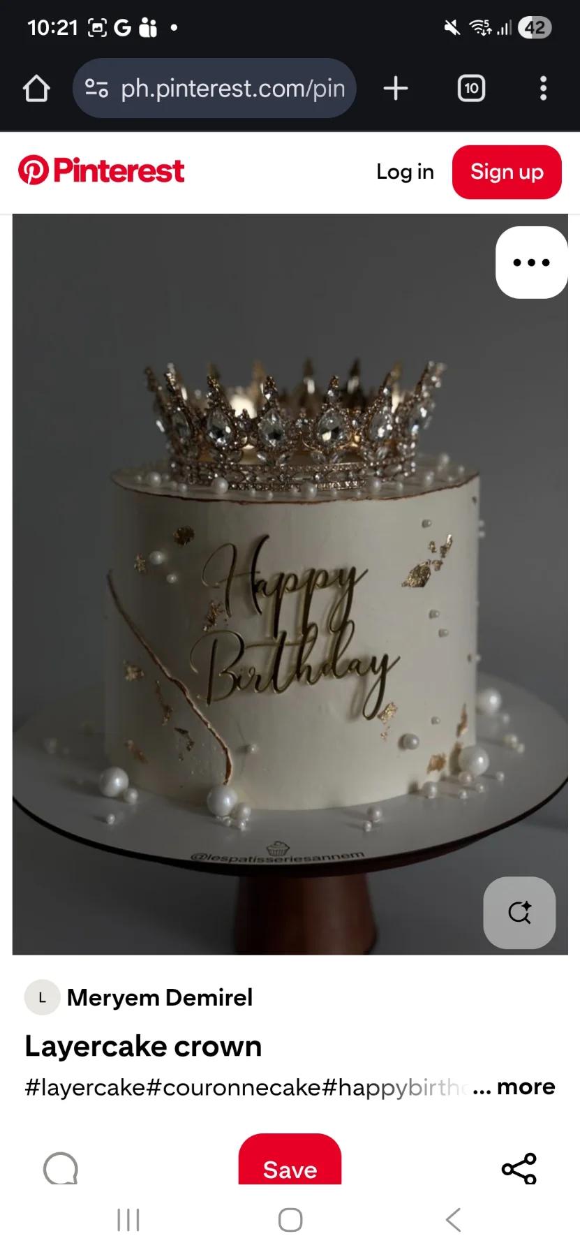 White 1-tier birthday cake with a large gold crown topper, gold leaf accents, and white pearls.