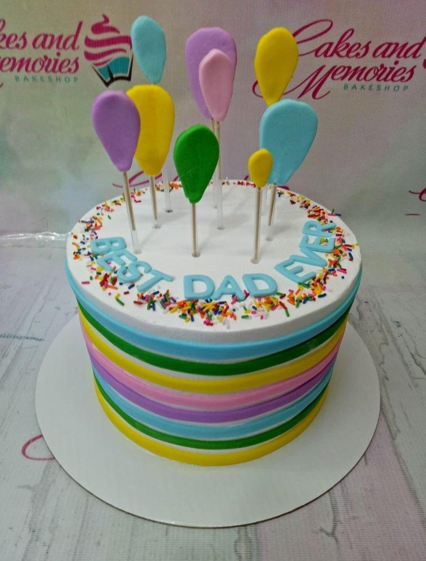 Colorful 1-tier birthday cake with rainbow stripes, balloon toppers, and 'BEST DAD EVER' message.