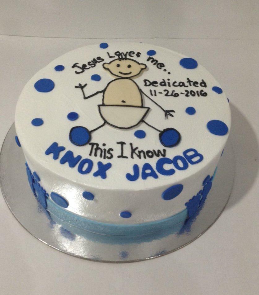 White round cake with blue polka dots and a hand-drawn baby illustration for a dedication ceremony.
