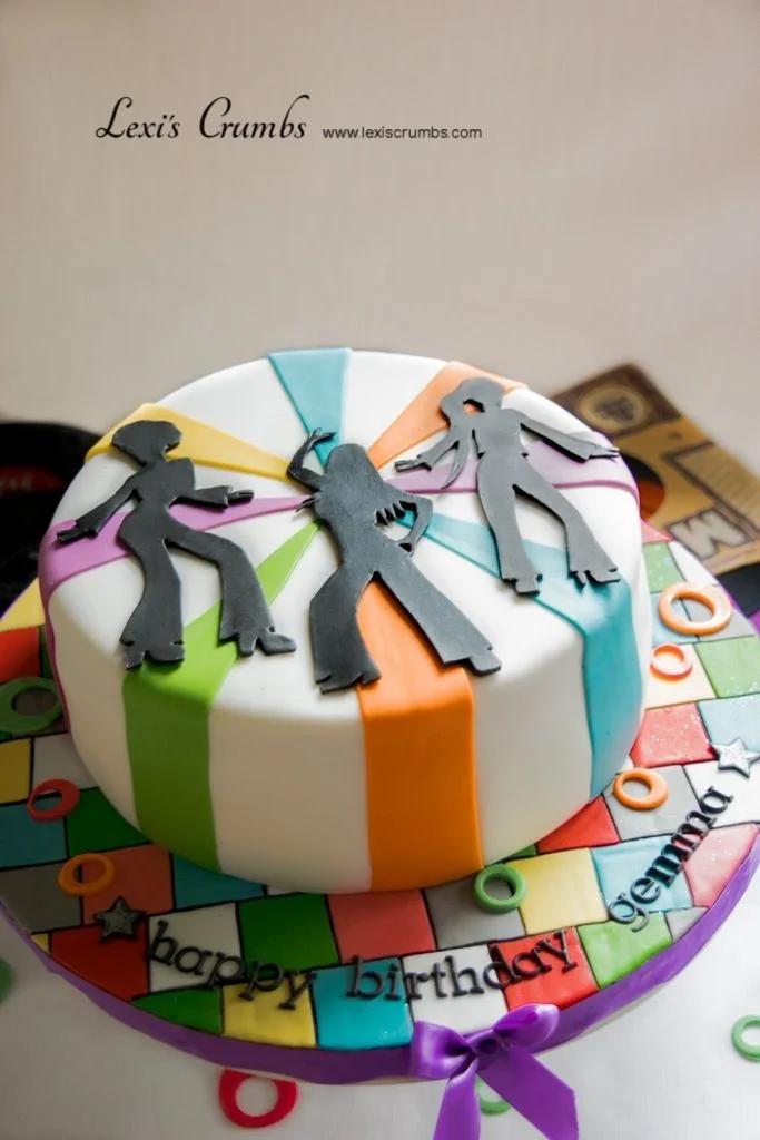 Disco themed birthday cake with black silhouettes of dancers and colorful fondant stripes on white icing.