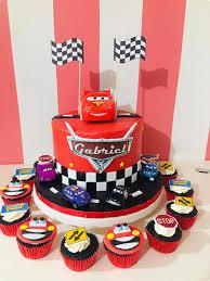 Red Disney Cars themed birthday cake for Gabriel featuring Lightning McQueen and a checkered racing flag design with matching cupcakes.