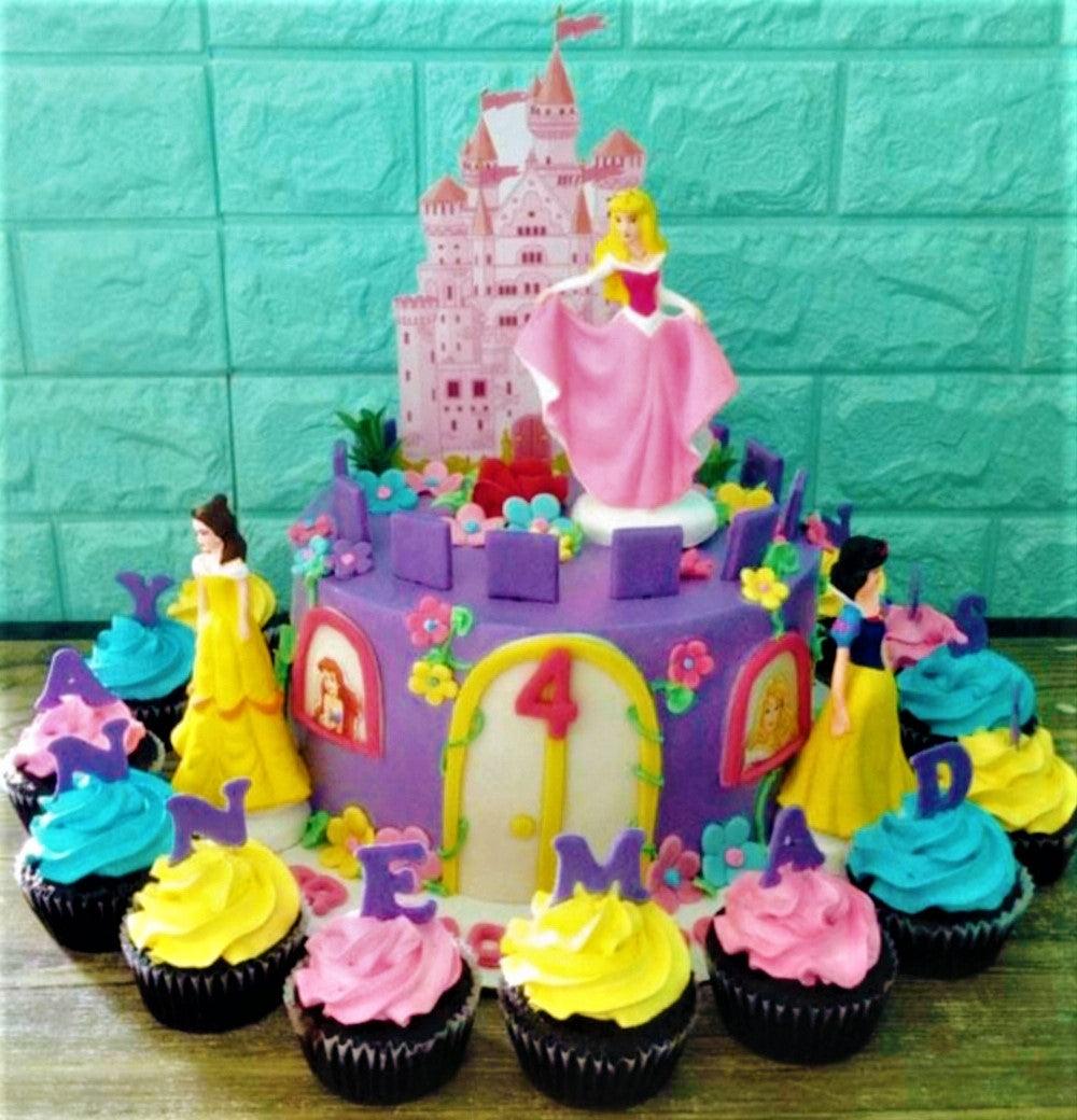 Purple princess castle cake with Disney Princess figurines and matching cupcakes