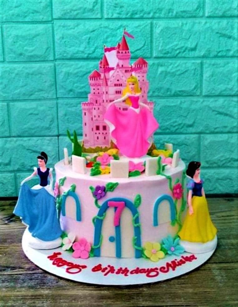 Pink Disney Princess themed cake featuring Aurora, Cinderella, and Snow White with a pink castle topper and floral icing decorations.