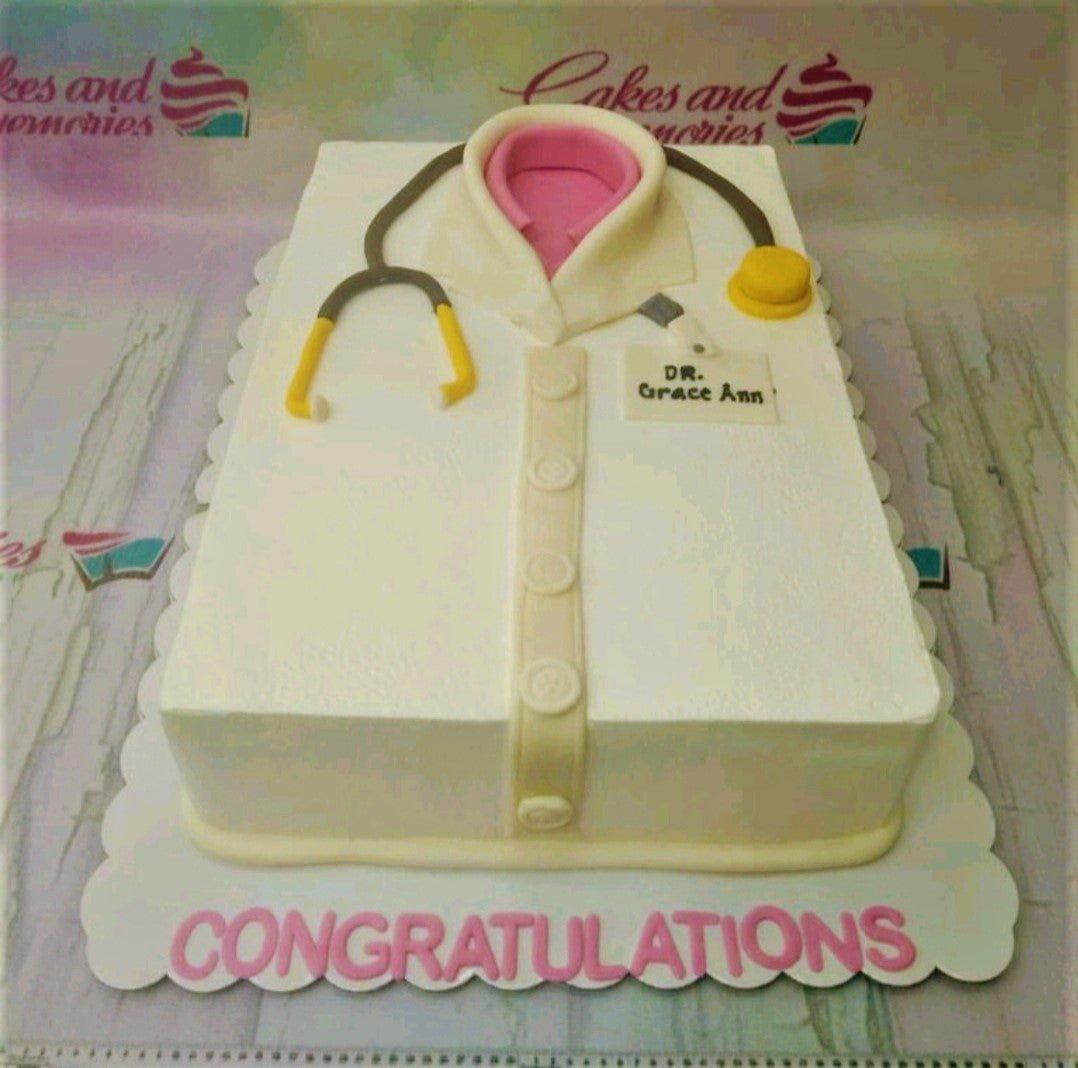 White rectangle doctor's coat cake with a pink shirt collar, stethoscope, and name tag for Dr. Grace Ann.