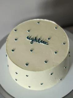 Minimalist ivory bento-style cake with navy blue cursive eighteen message and tiny navy heart accents