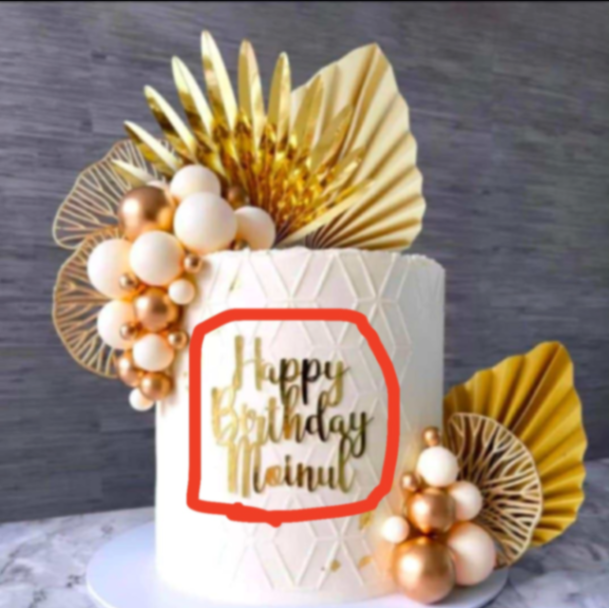 White 1-tier birthday cake with geometric textured icing, gold and cream plastic balls, and gold paper palm leaves.