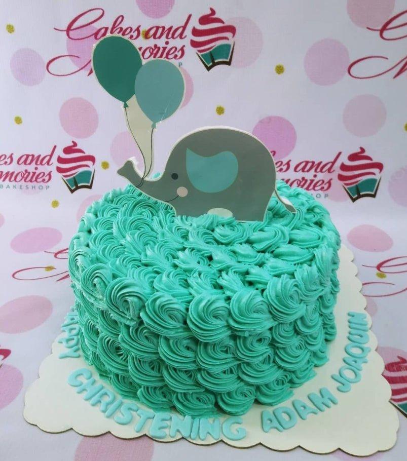Teal rosette icing cake with a grey elephant and balloon printout topper for a christening celebration.