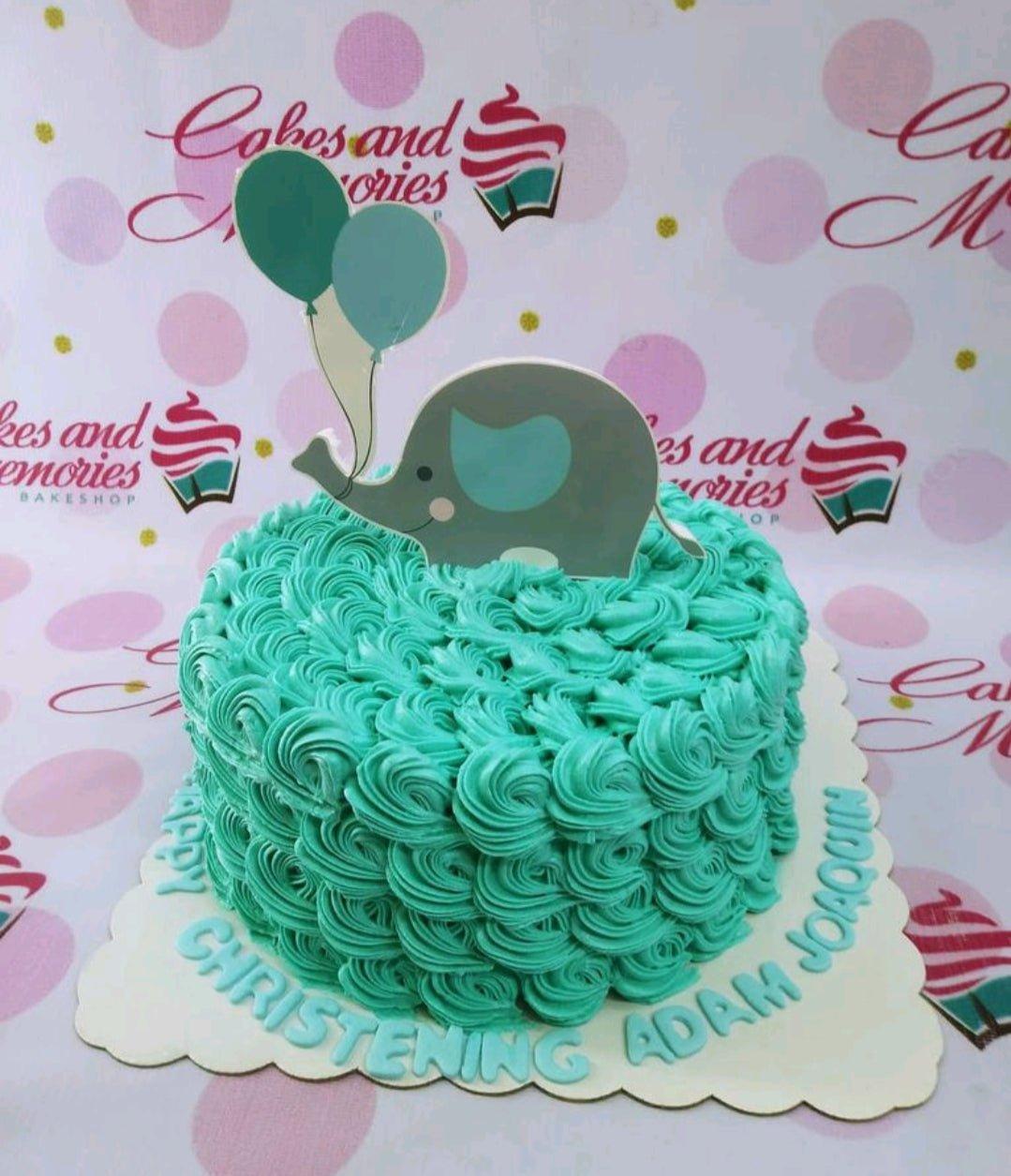 Teal rosette cake with a cute elephant and balloon printout topper for a christening celebration.
