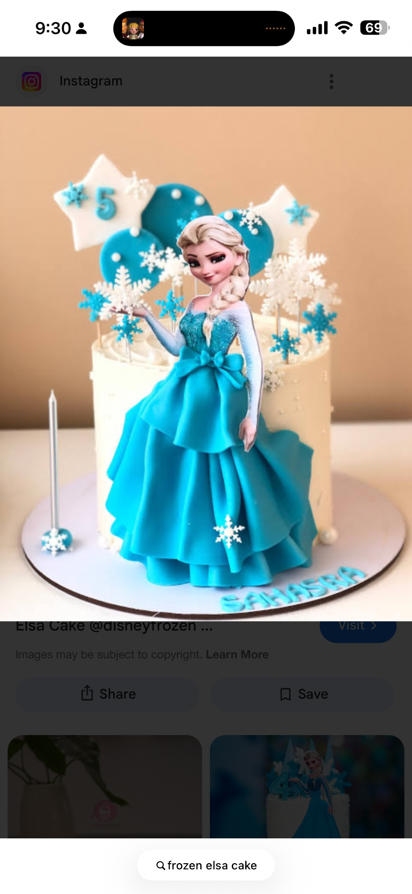 White 1-tier Elsa Frozen birthday cake with blue fondant dress, snowflake toppers, and star decorations