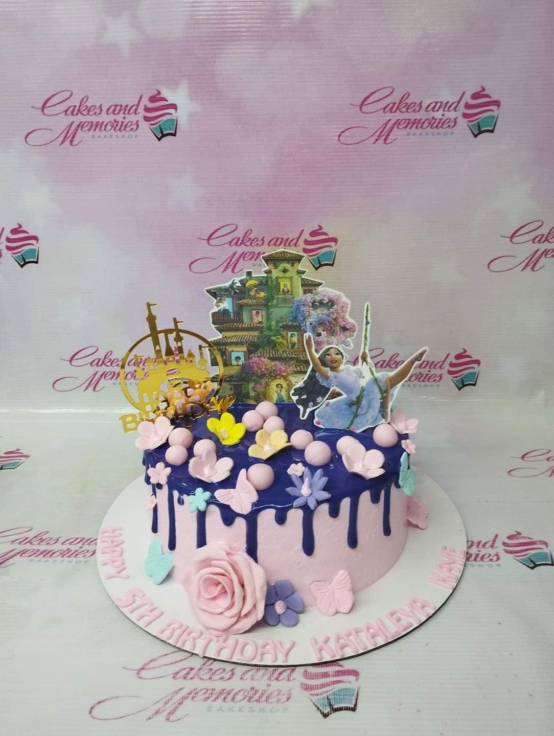 Pink 1-tier Encanto themed birthday cake with purple drip, pink fondant flowers, and Isabela character topper.