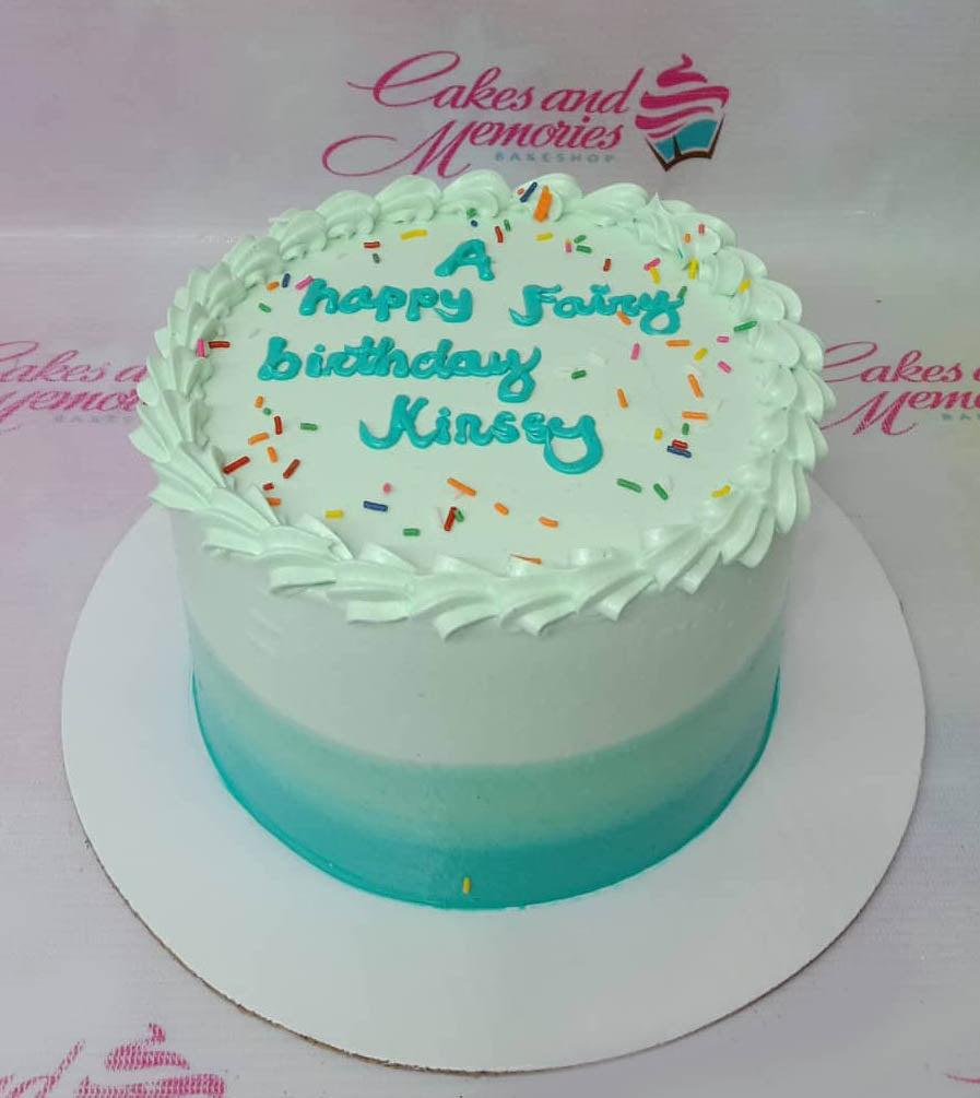 Single tier teal gradient birthday cake with white icing borders, colorful sprinkles, and a blue piped message.