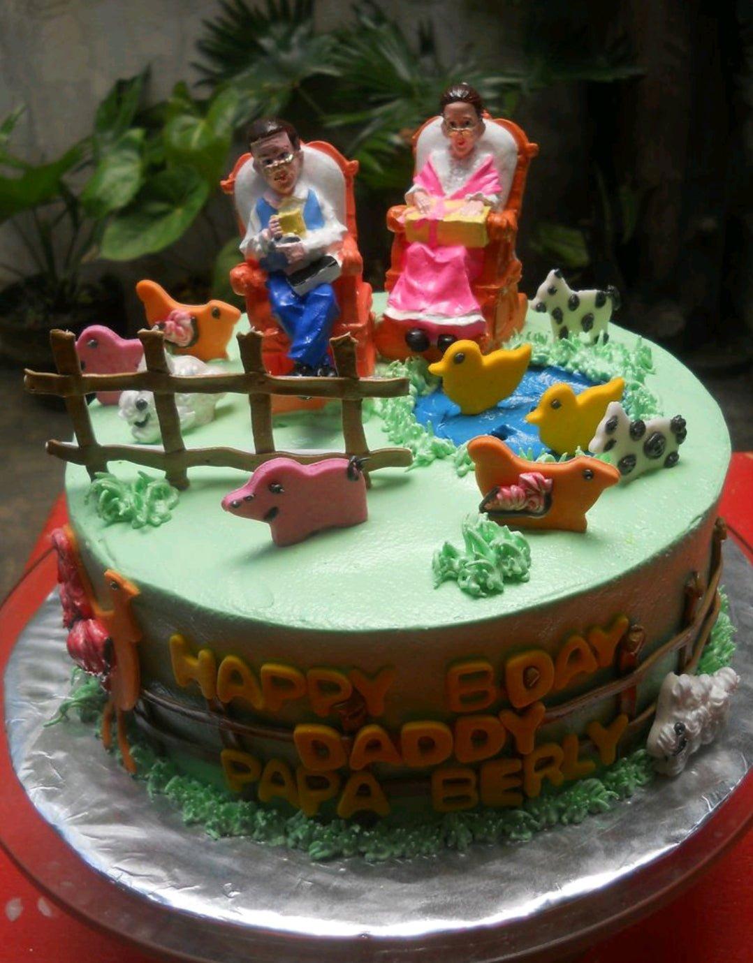 Farm themed birthday cake with 3D fondant figures of a couple in rocking chairs, farm animals, and a pond.