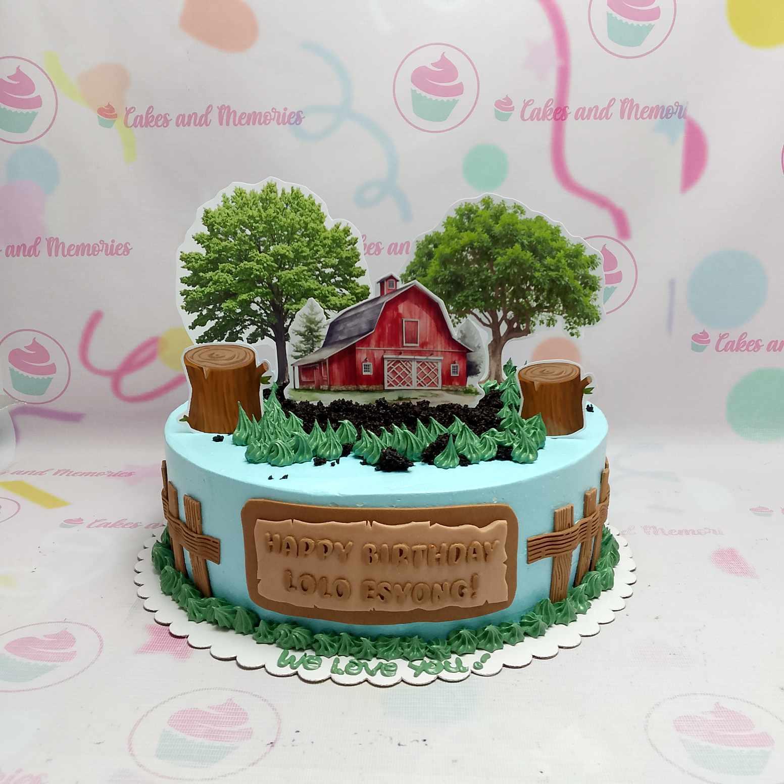 Light blue farm themed birthday cake for Lolo Esyong featuring a red barn, trees, and wooden fence decorations.