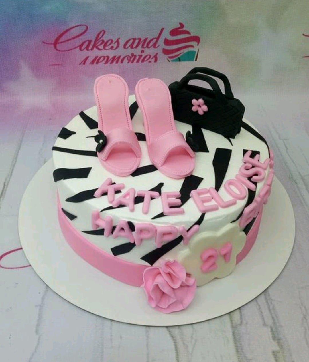 Zebra print fashion cake with pink high heels and a black handbag fondant toppers.
