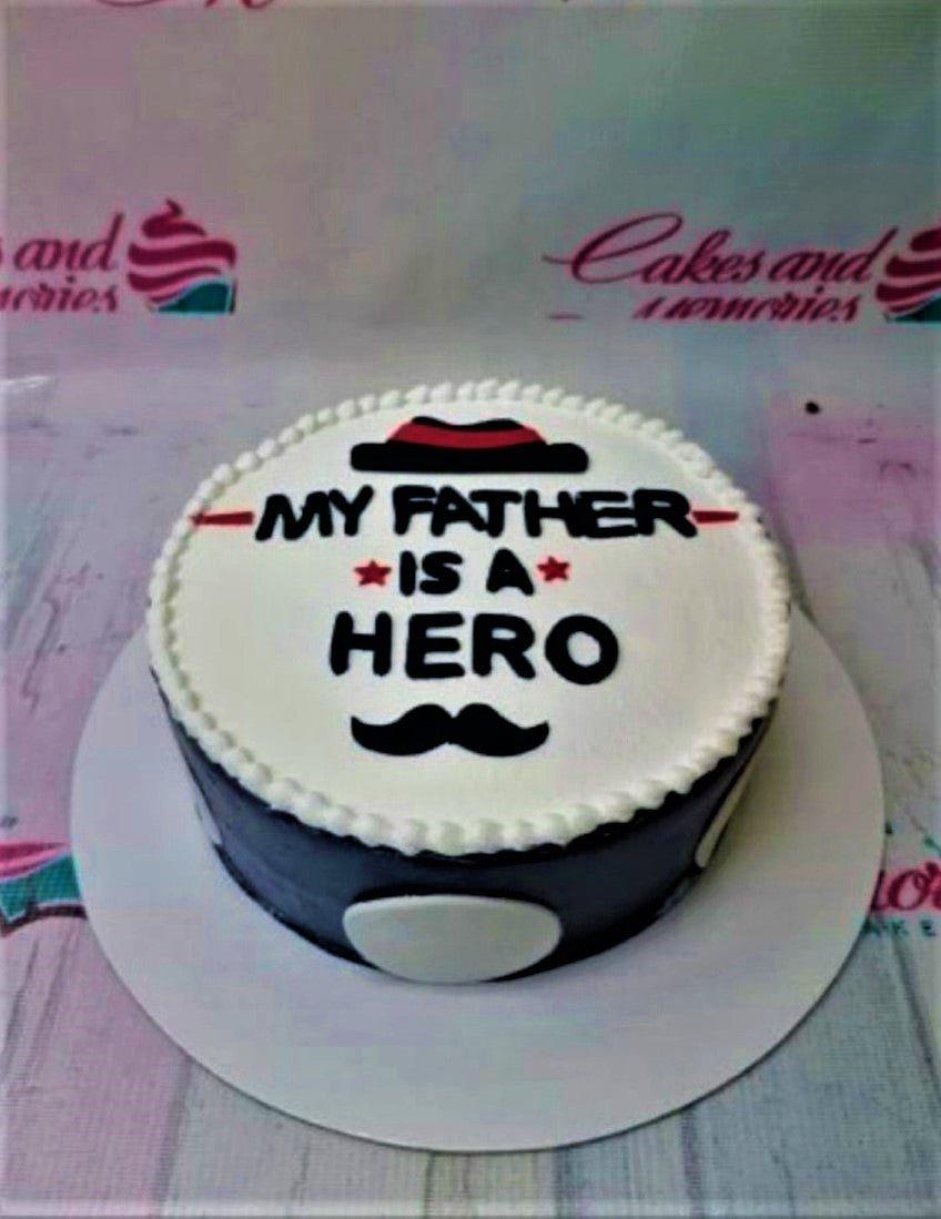 Minimalist white and black father's day cake with a hat and mustache design and the message My Father Is A Hero.