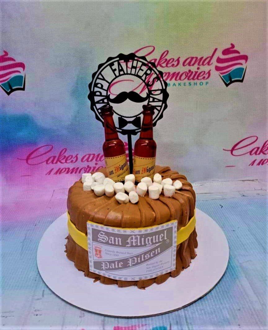 Brown textured icing cake designed like a beer barrel with San Miguel Pale Pilsen labels and marshmallow foam.