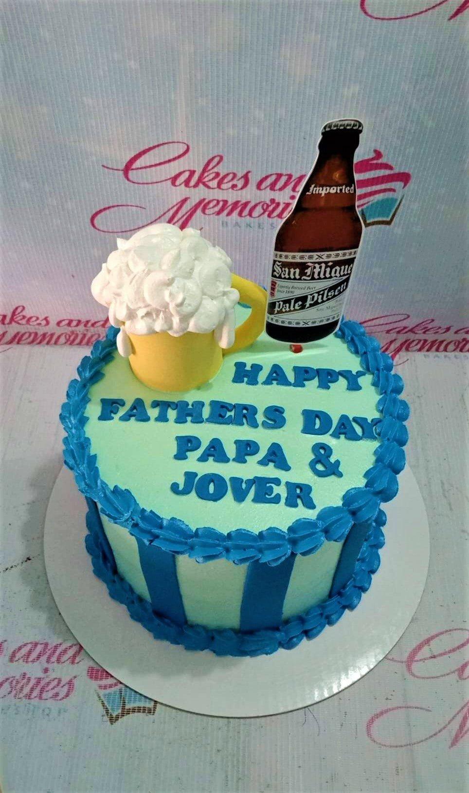 Light green Father's Day cake with blue icing borders, blue vertical stripes, a fondant beer mug, and a San Miguel beer bottle printout.