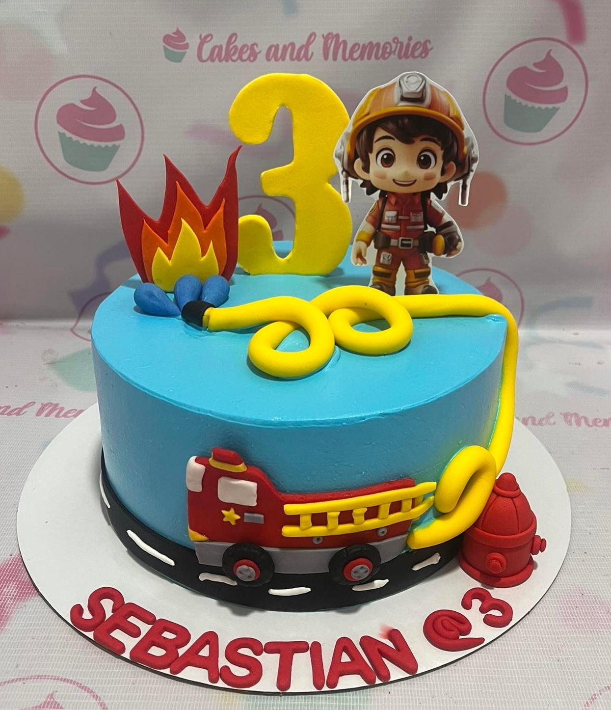 Light blue firefighter themed birthday cake with a fire truck, fire hydrant, and a cute firefighter character topper.
