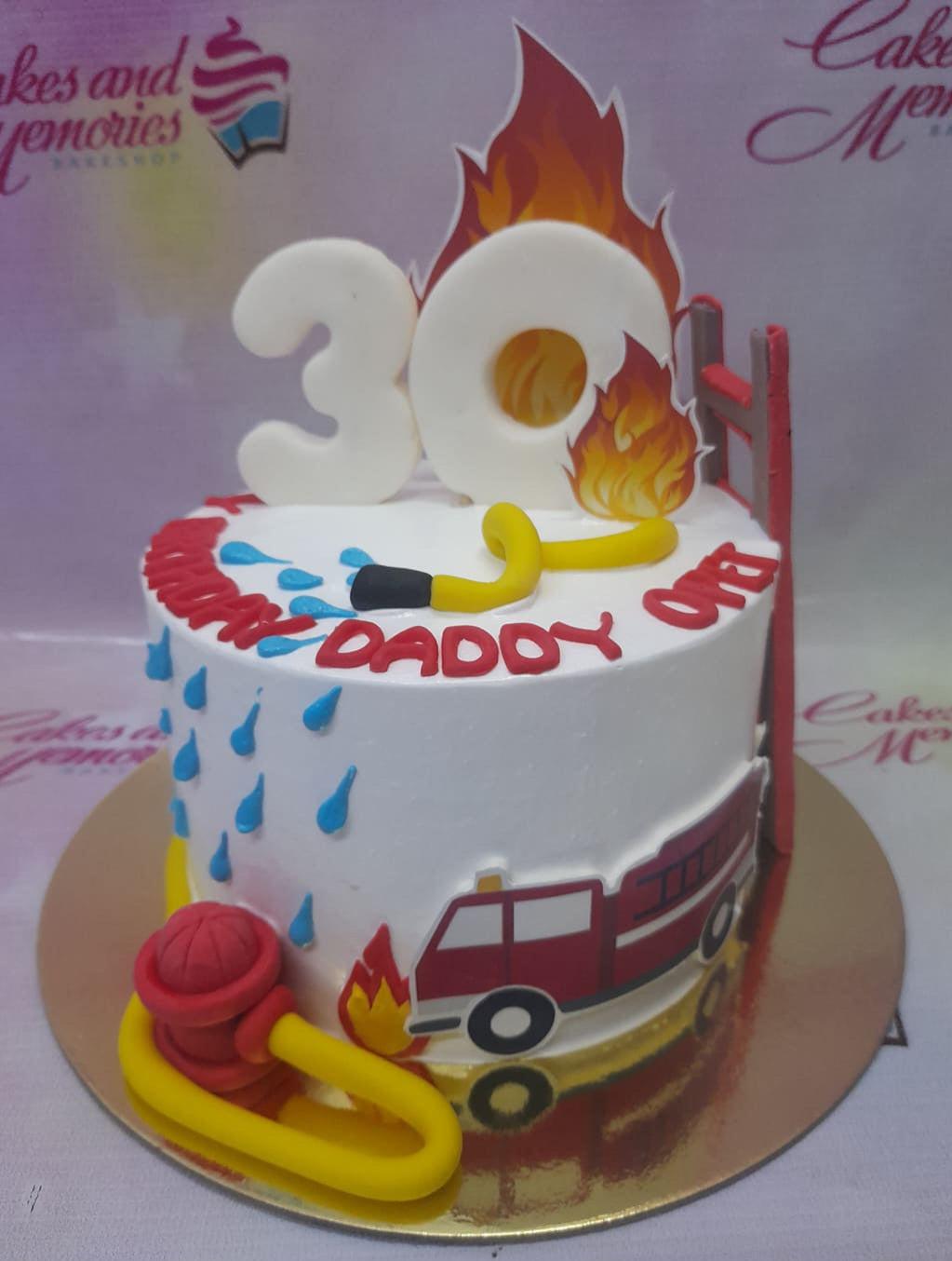 White firefighter themed birthday cake with a red fire truck, yellow hose, and large white number 30 topper with flames.