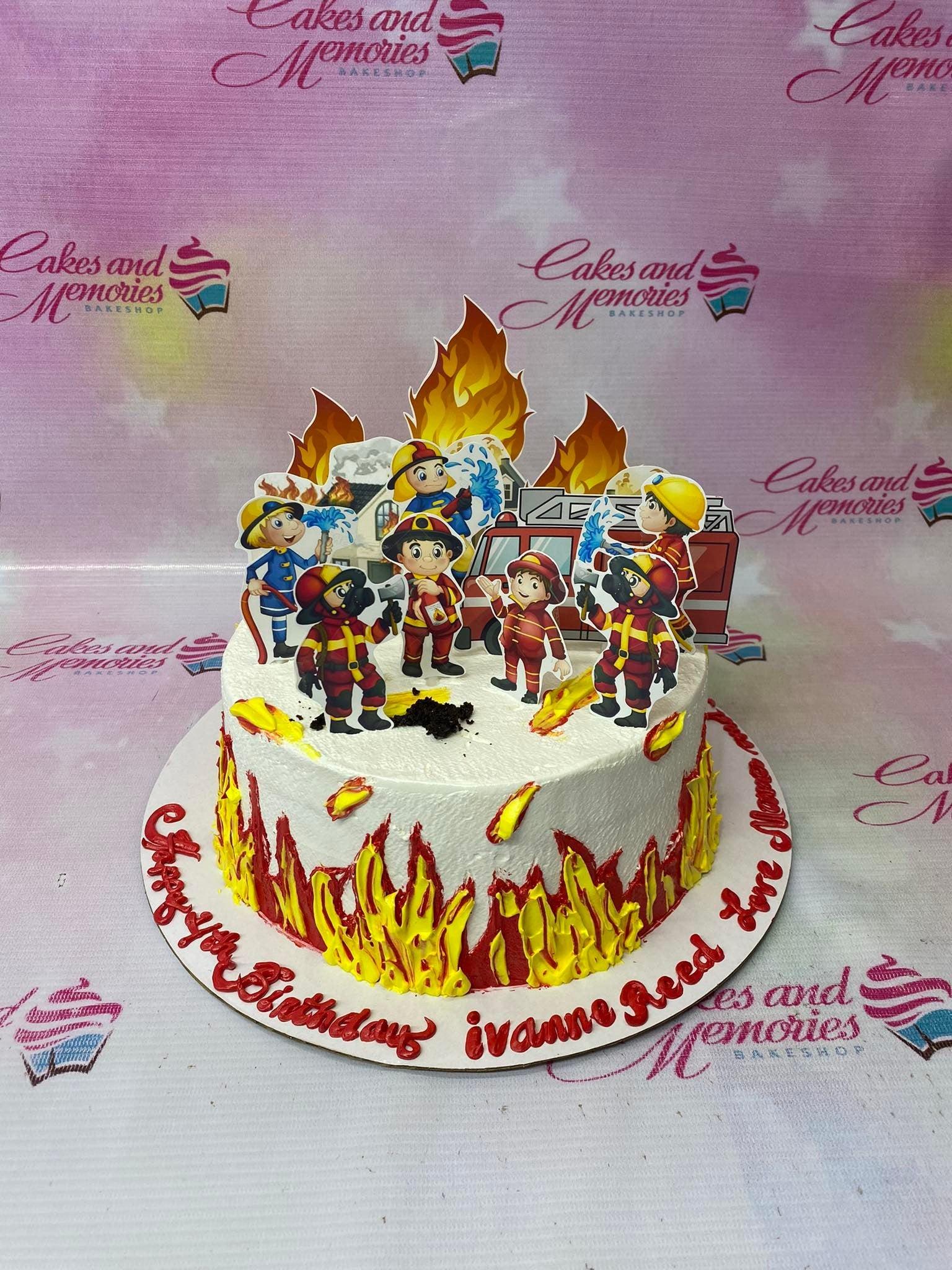 Firefighter themed birthday cake with fire truck and fireman printouts and red and yellow icing flames