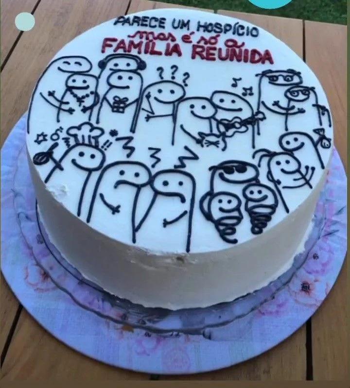 White bento cake with black hand-drawn Flork characters and a humorous Portuguese message in red and black icing.