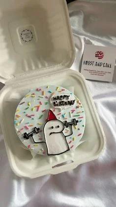 White bento cake with a hand-drawn Flork character lifting weights and colorful sprinkles.