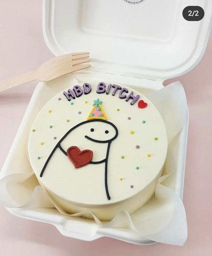 Bento cake with a minimalist Flork character wearing a party hat and holding a red heart, featuring colorful sprinkles and a humorous message.