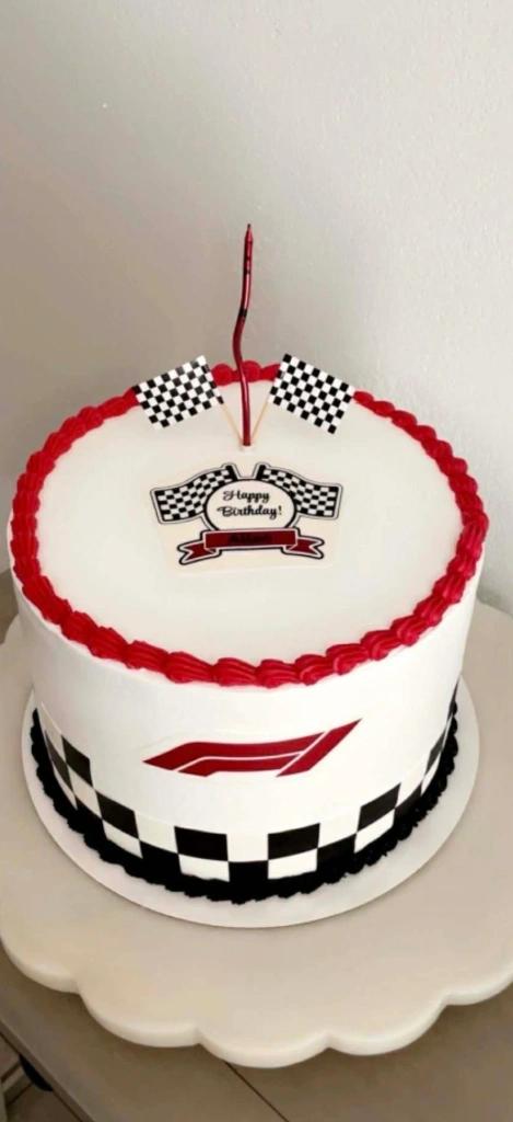 White 1-tier Formula 1 racing themed birthday cake with red and black borders and checkered flag toppers.