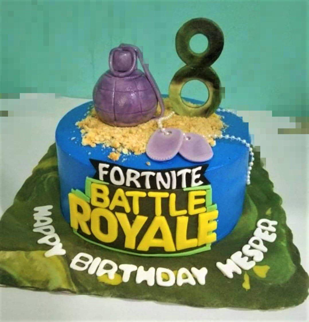 Fortnite Battle Royale themed blue cake with a purple grenade, dog tags, and a camouflage number 8 topper on a camo base.