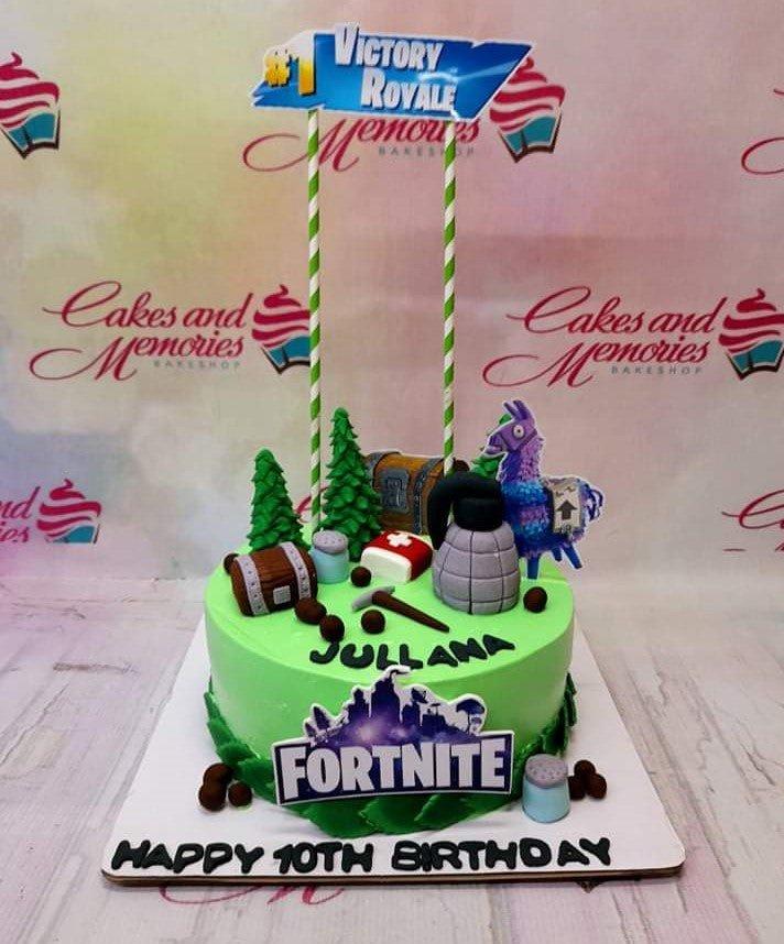 Green Fortnite themed birthday cake with fondant trees, loot chests, a llama, and a grenade topper.
