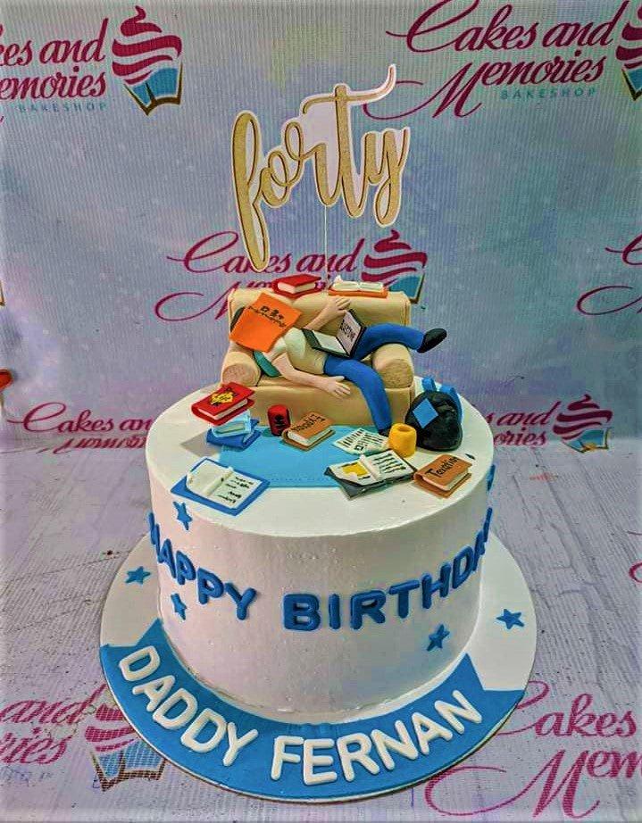 White 1-tier birthday cake for Daddy Fernan featuring a 3D fondant figure of a man sleeping on a sofa surrounded by books and a gold forty topper.