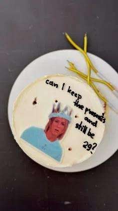 White bento cake with a printout of Jennifer Aniston wearing a crown and a funny 29th birthday message in black icing.