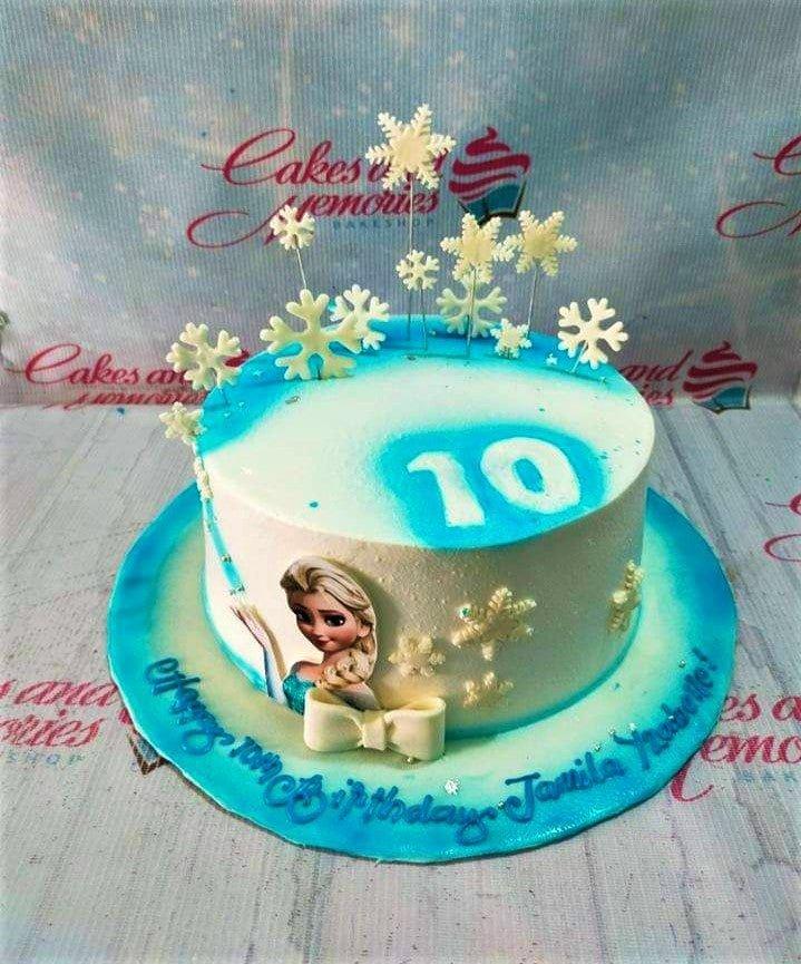 Frozen themed Elsa birthday cake with blue and white icing, snowflake toppers, and a large number 10.