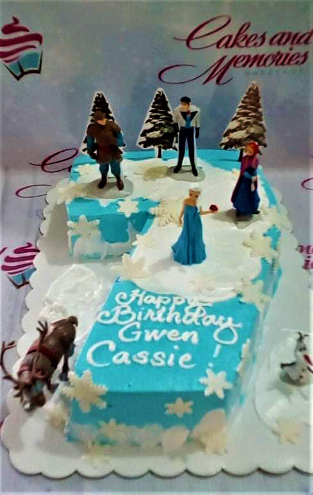 Frozen themed number 7 shaped cake in light blue and white with Elsa, Anna, Kristoff, Hans, Sven, and Olaf figurines.